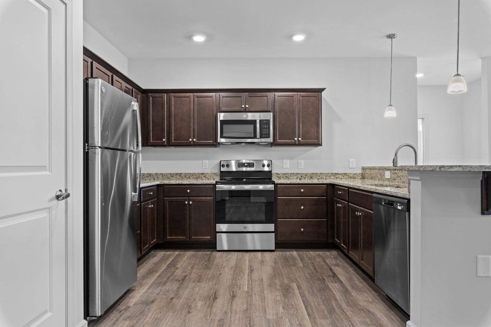 a kitchen with stainless steel appliances granite countertop a refrigerator and a stove