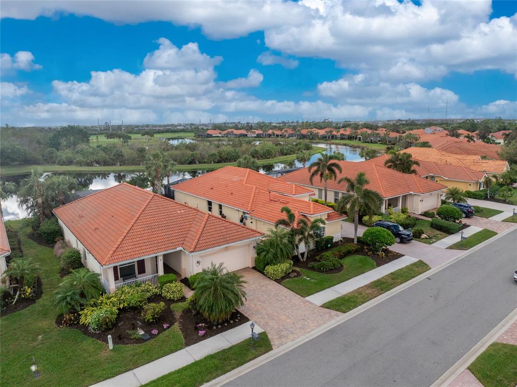 an aerial view of residential houses with outdoor space and ocean view