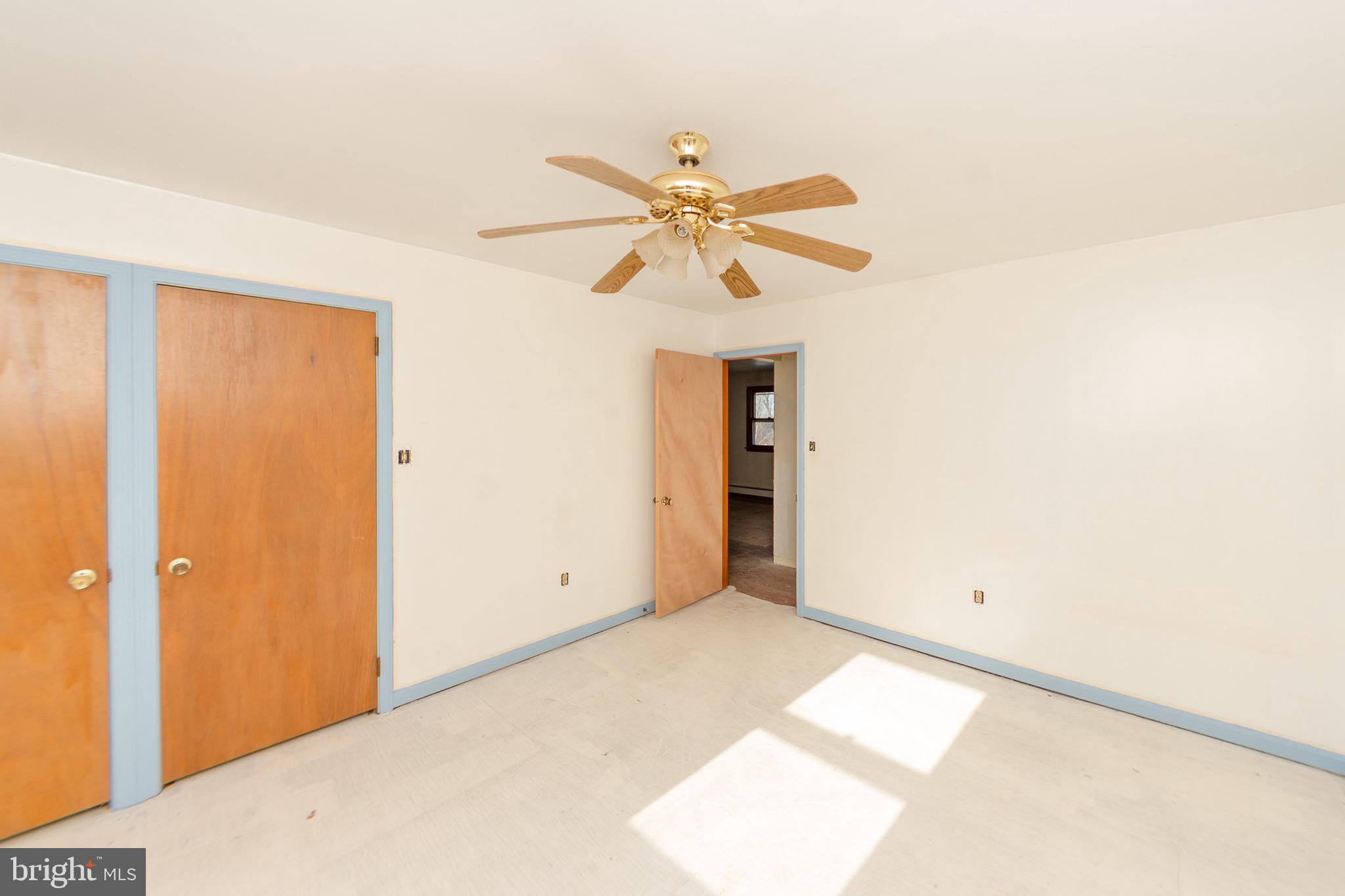 a view of a big room with chandelier fan