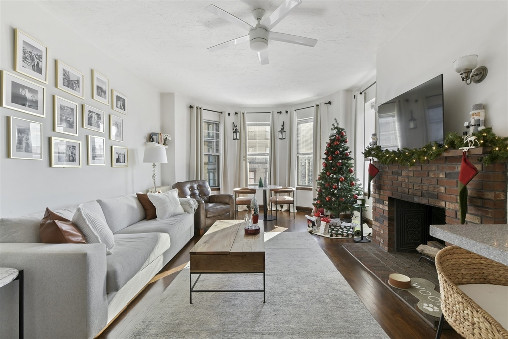 a living room with furniture a fireplace and a floor to ceiling window