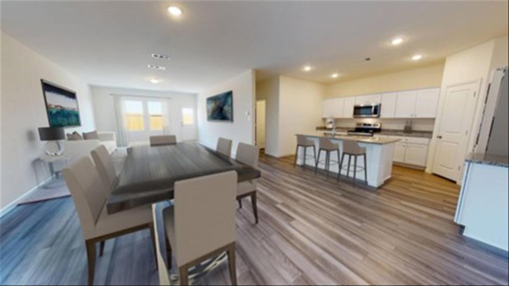 a view of a dining room with furniture a rug and wooden floor