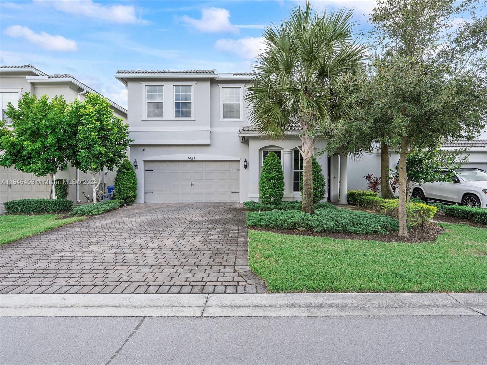 a front view of a house with a yard and a garage