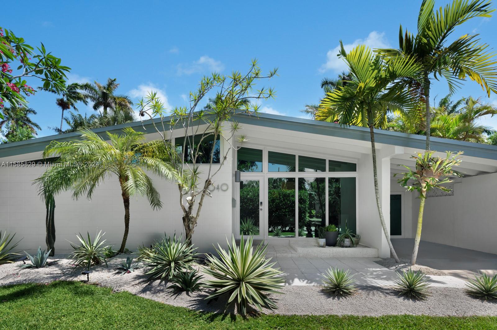 a couple of potted plants in front of house