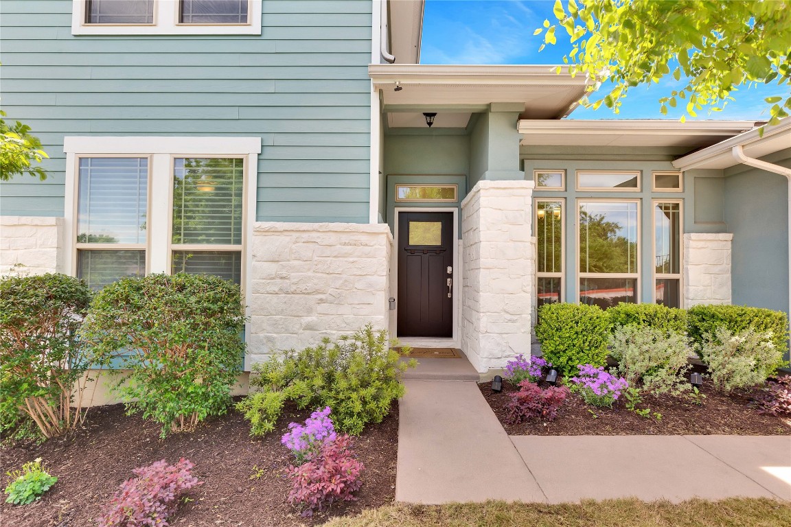 a front view of a house with a lots of potted plants