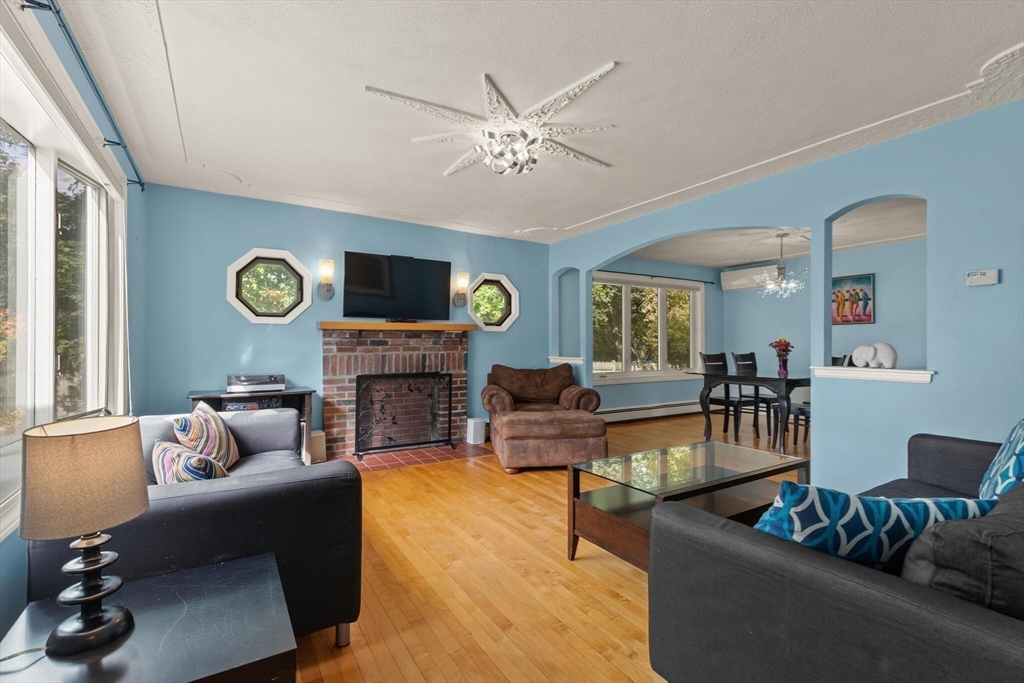 a living room with fireplace furniture and a wooden floor