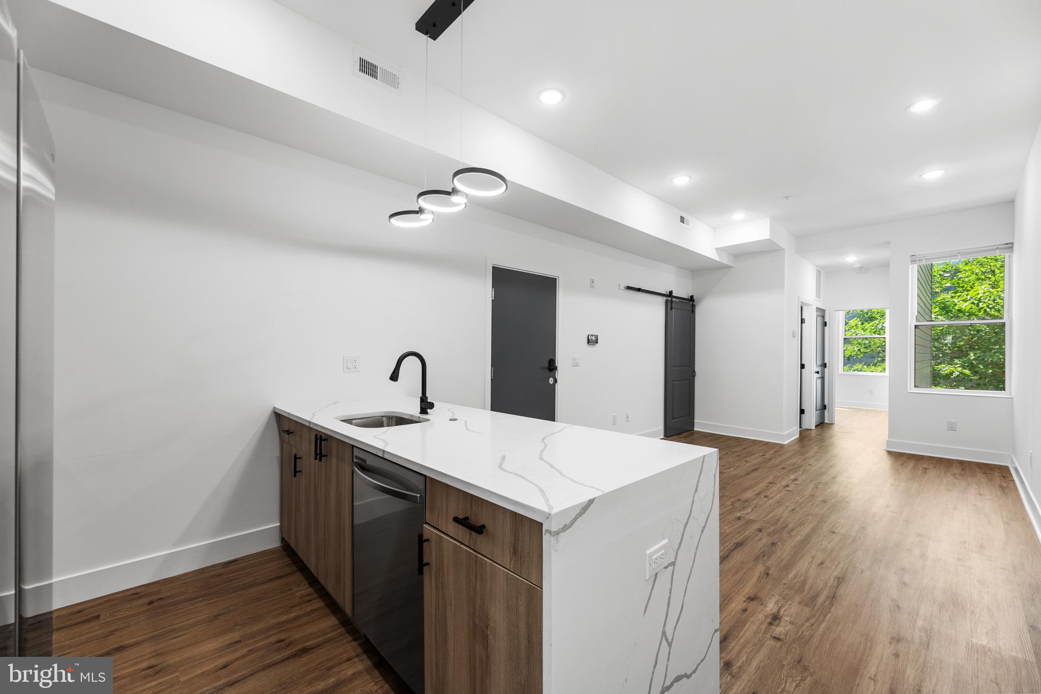 a kitchen with a sink and wooden floor