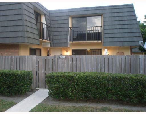 a view of a house with a small yard and wooden fence