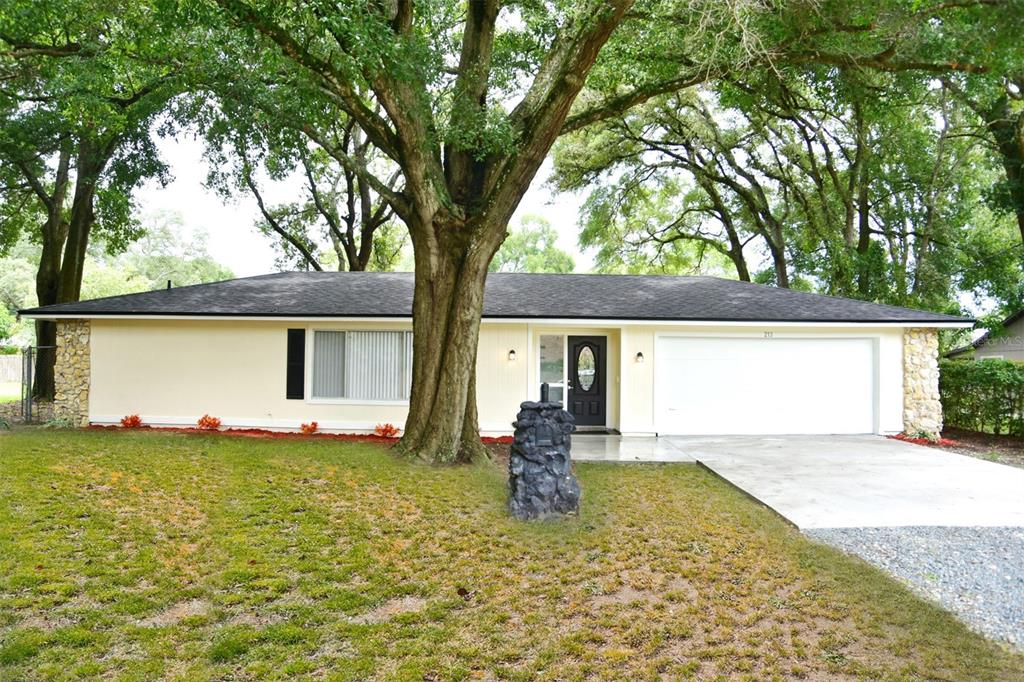 a front view of house with yard and trees