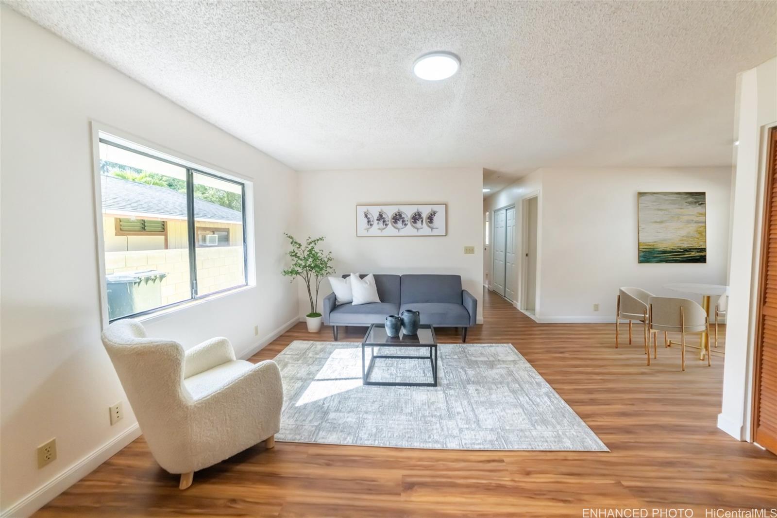 a living room with furniture wooden floor and a large window