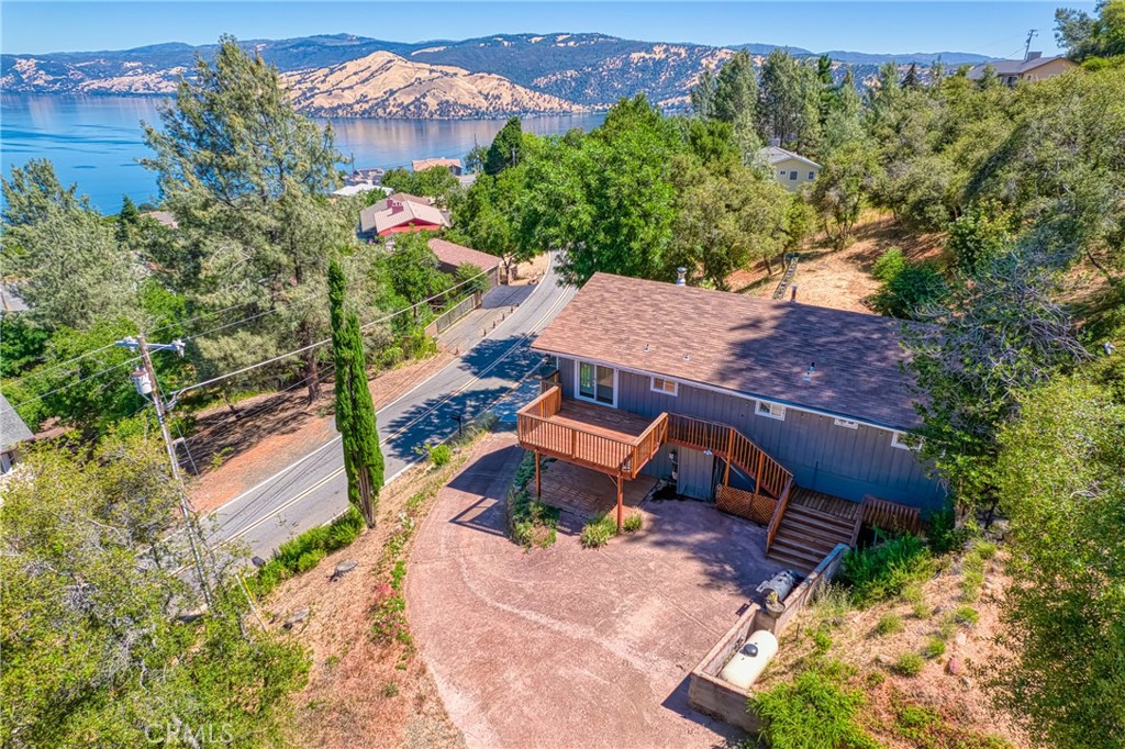 an aerial view of a house with a yard and lake view