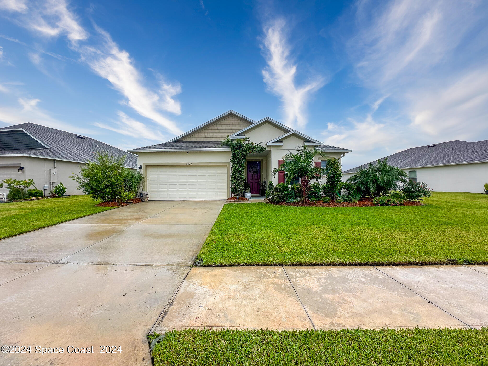 a front view of a house with a yard and garage