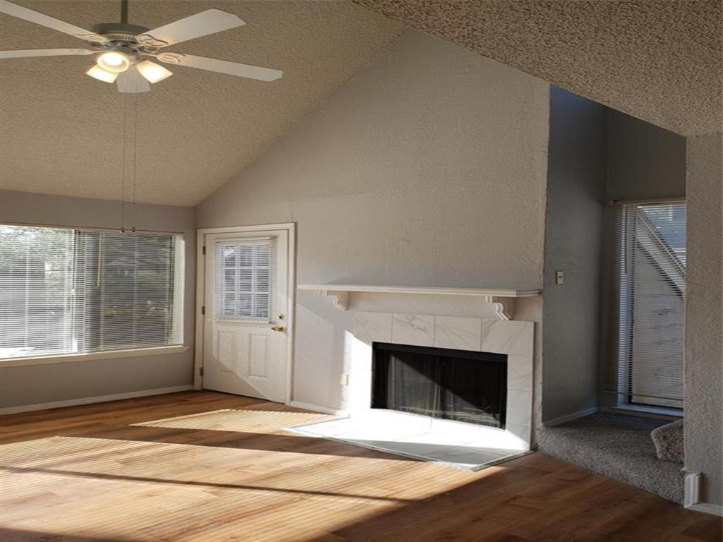 a view of an empty room with a fireplace and a window