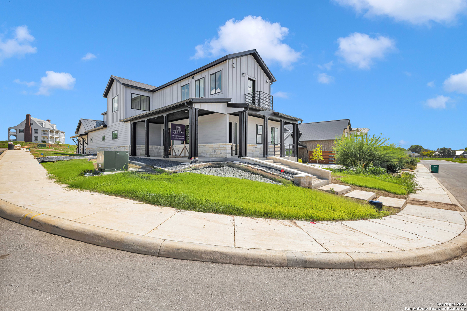 a front view of a house with a yard and trees