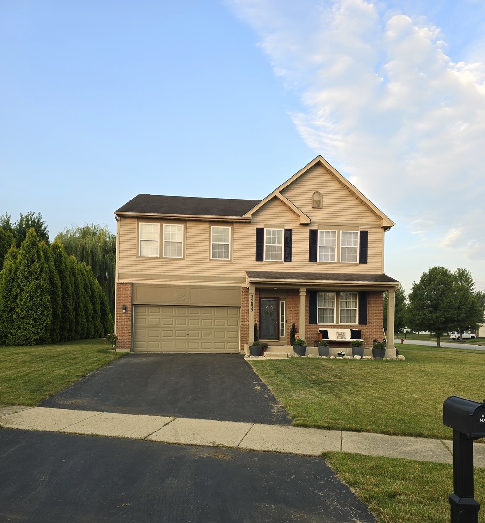 a front view of a house with a yard and lake view