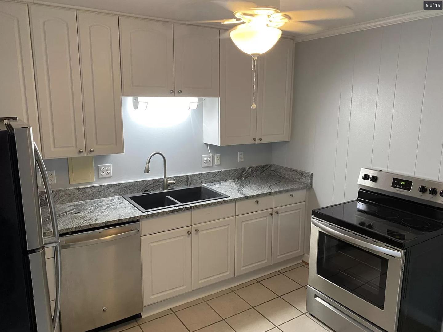 a kitchen with stainless steel appliances granite countertop a sink stove and cabinets