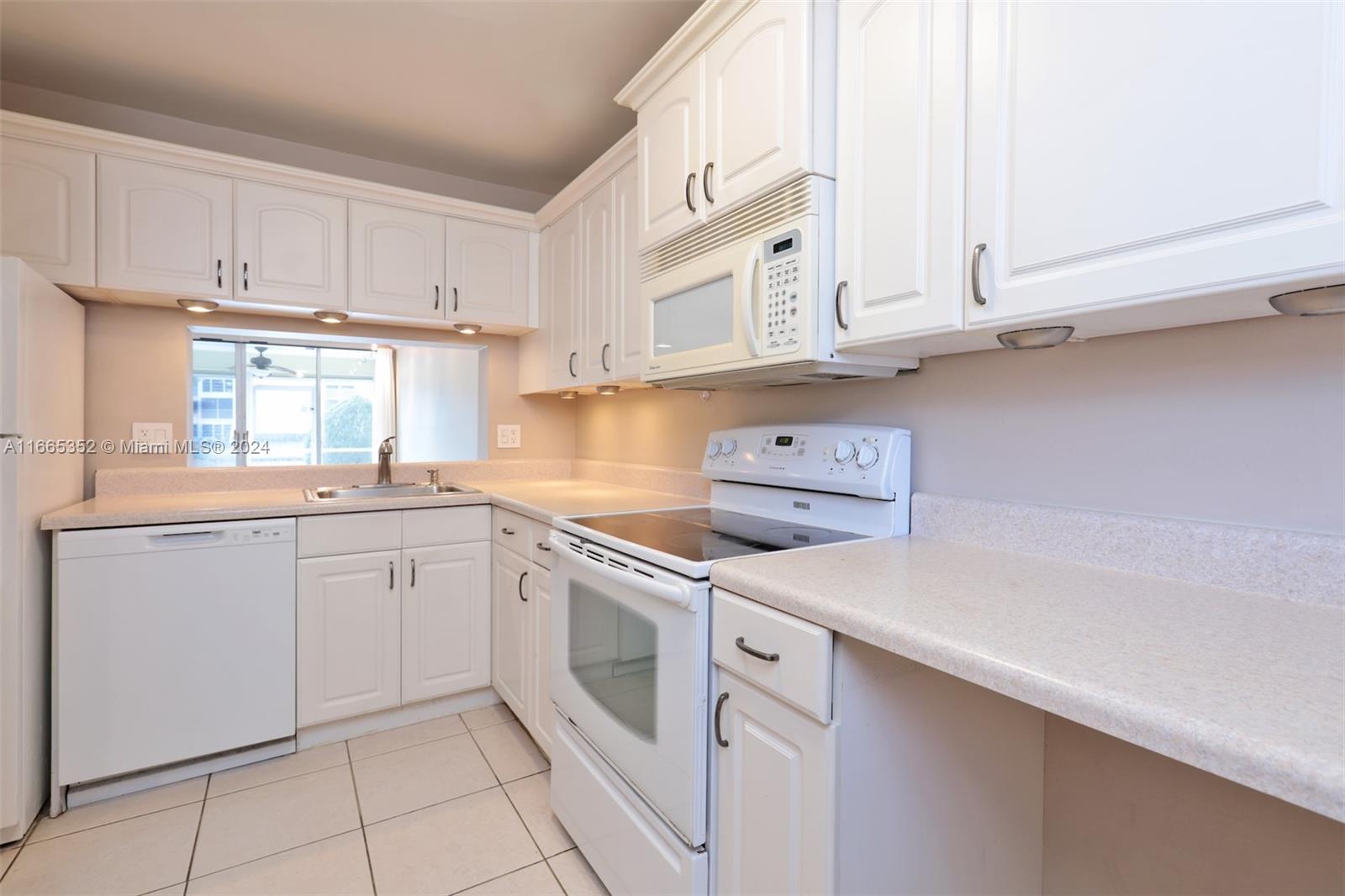 a kitchen with white cabinets and white appliances