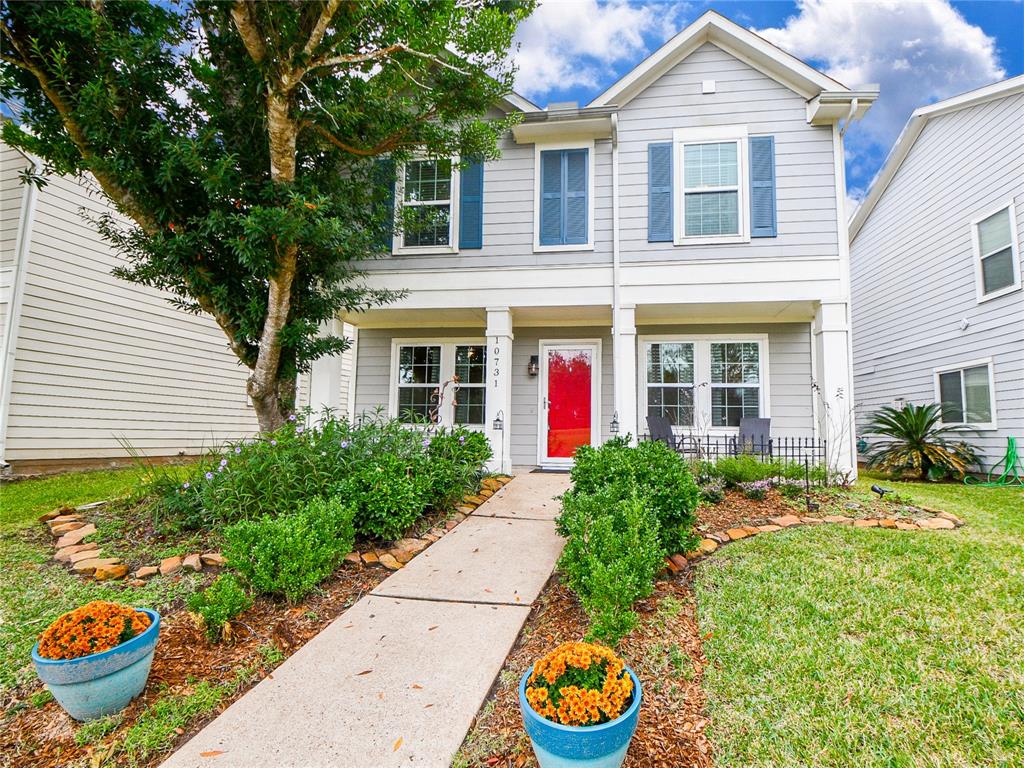 a front view of a house with a yard and potted plants