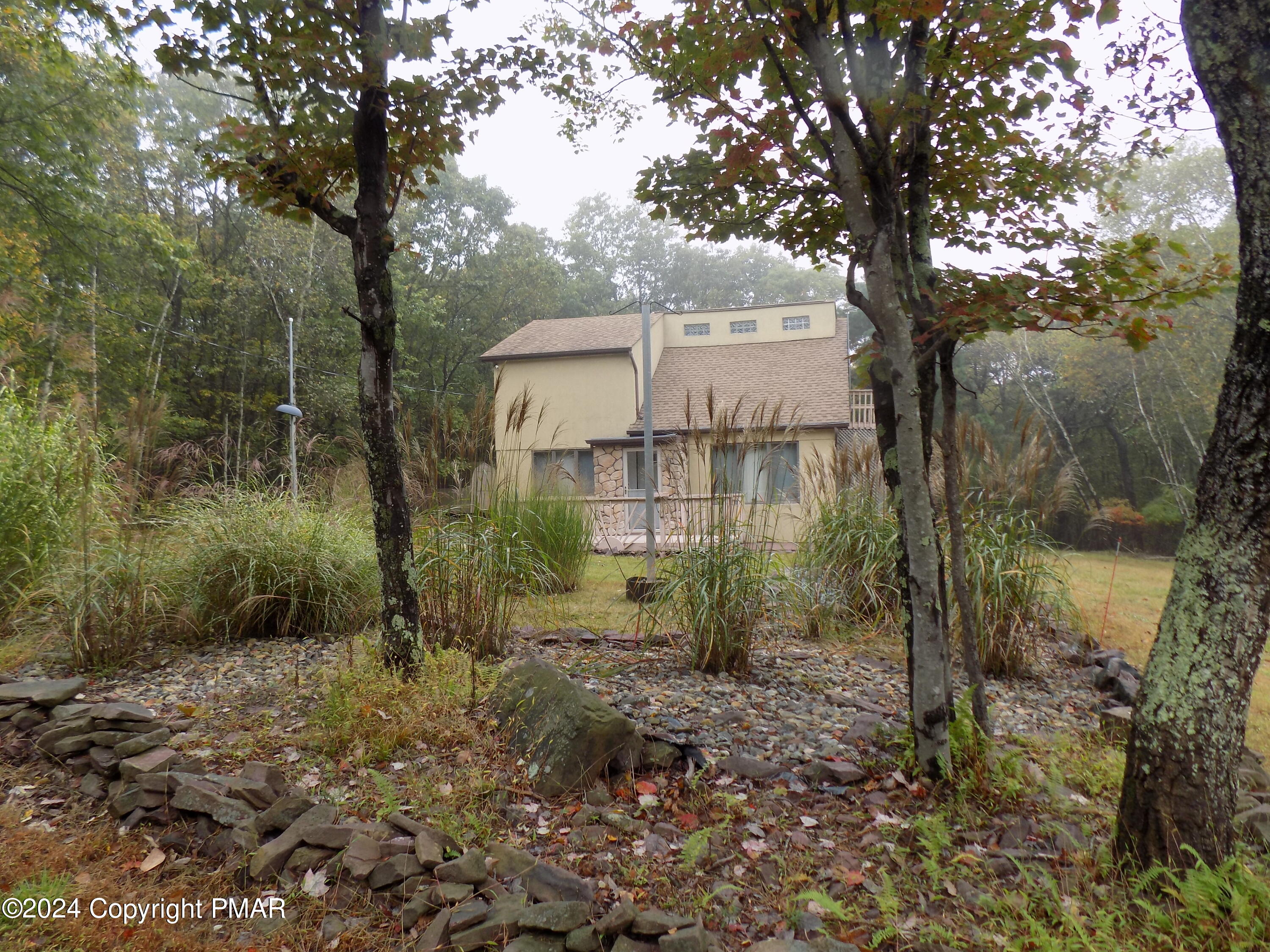 a view of a house with a tree and a yard