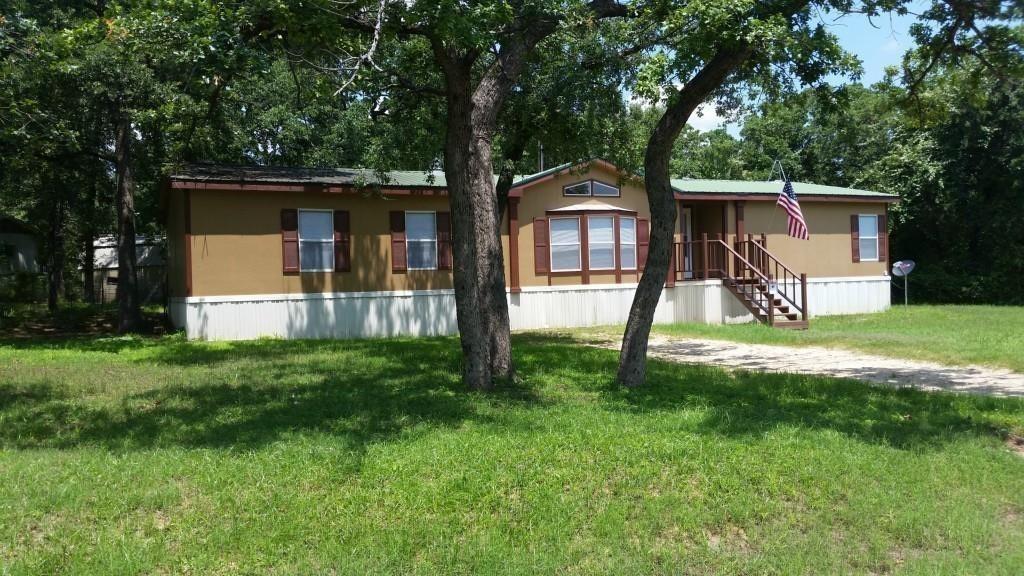 a view of a house with backyard and a tree