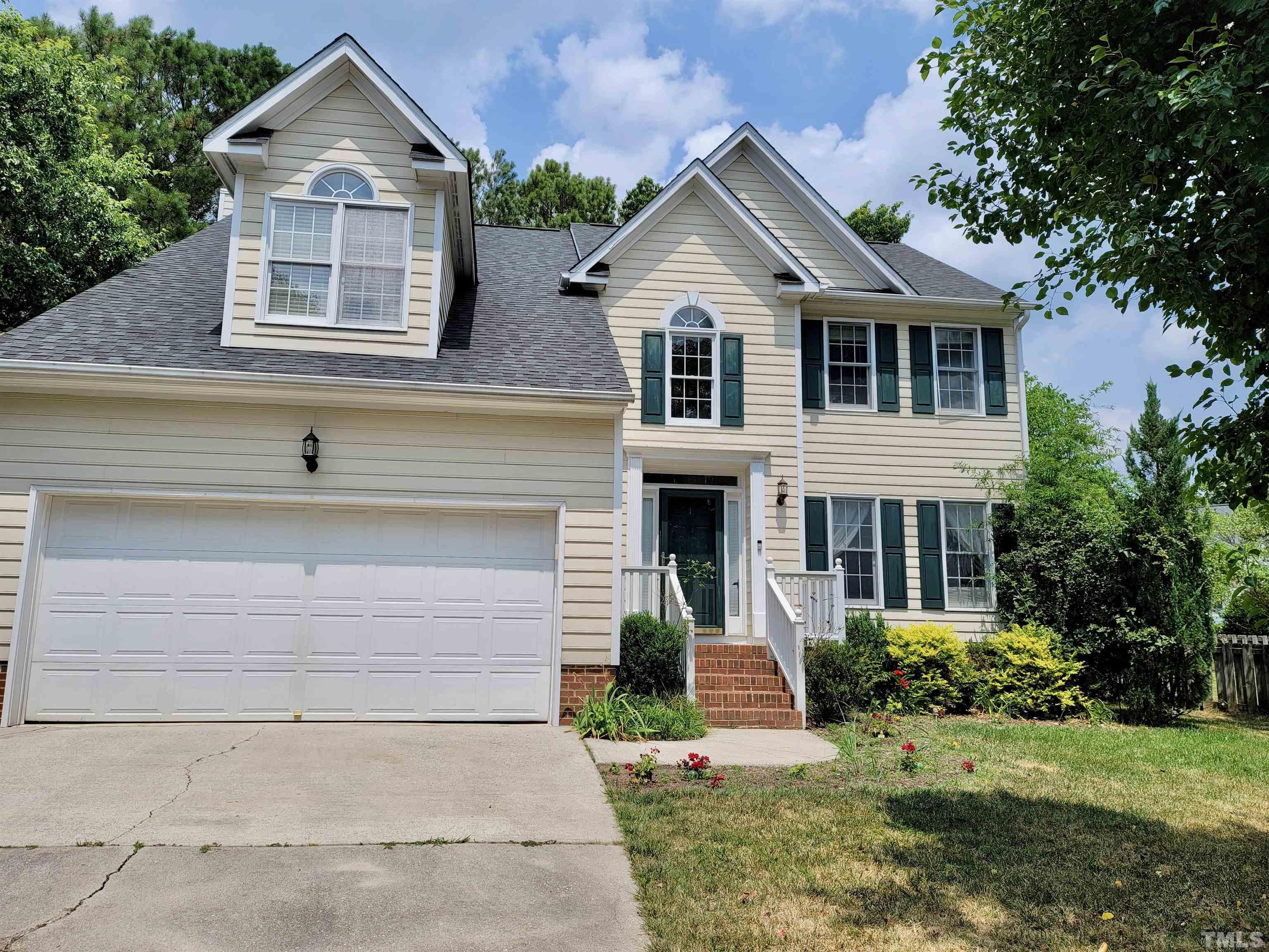 a front view of a house with a yard and trees