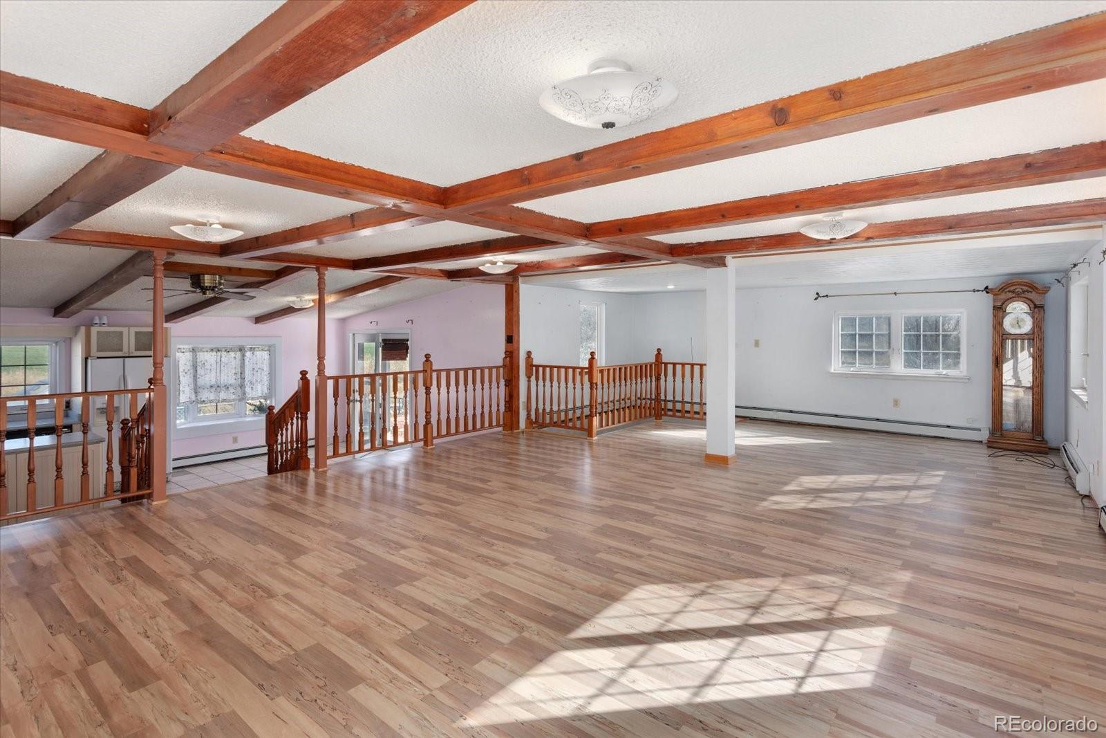 a view of a room with wooden floor stairs and a way to a window