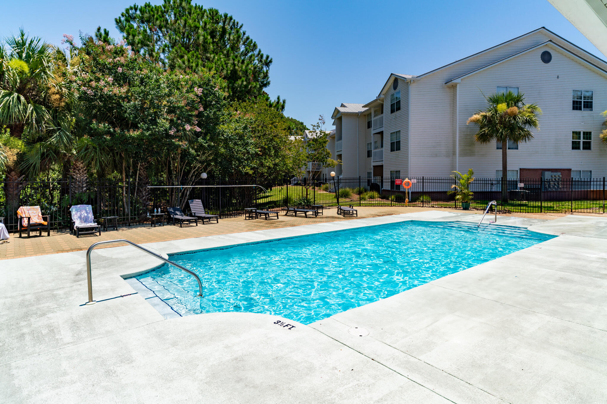 swimming pool view with a seating space and a garden