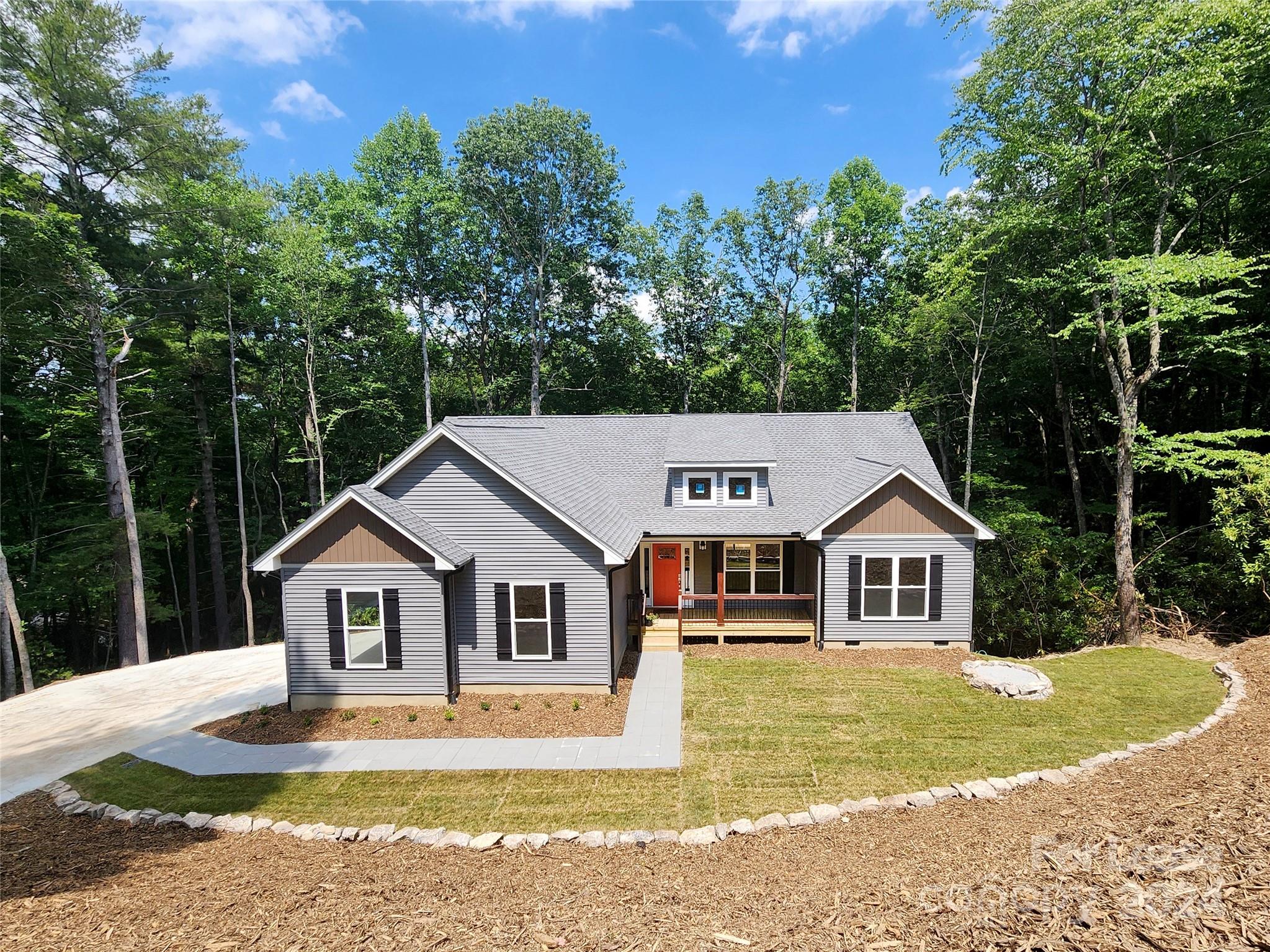 a front view of a house with a yard and trees