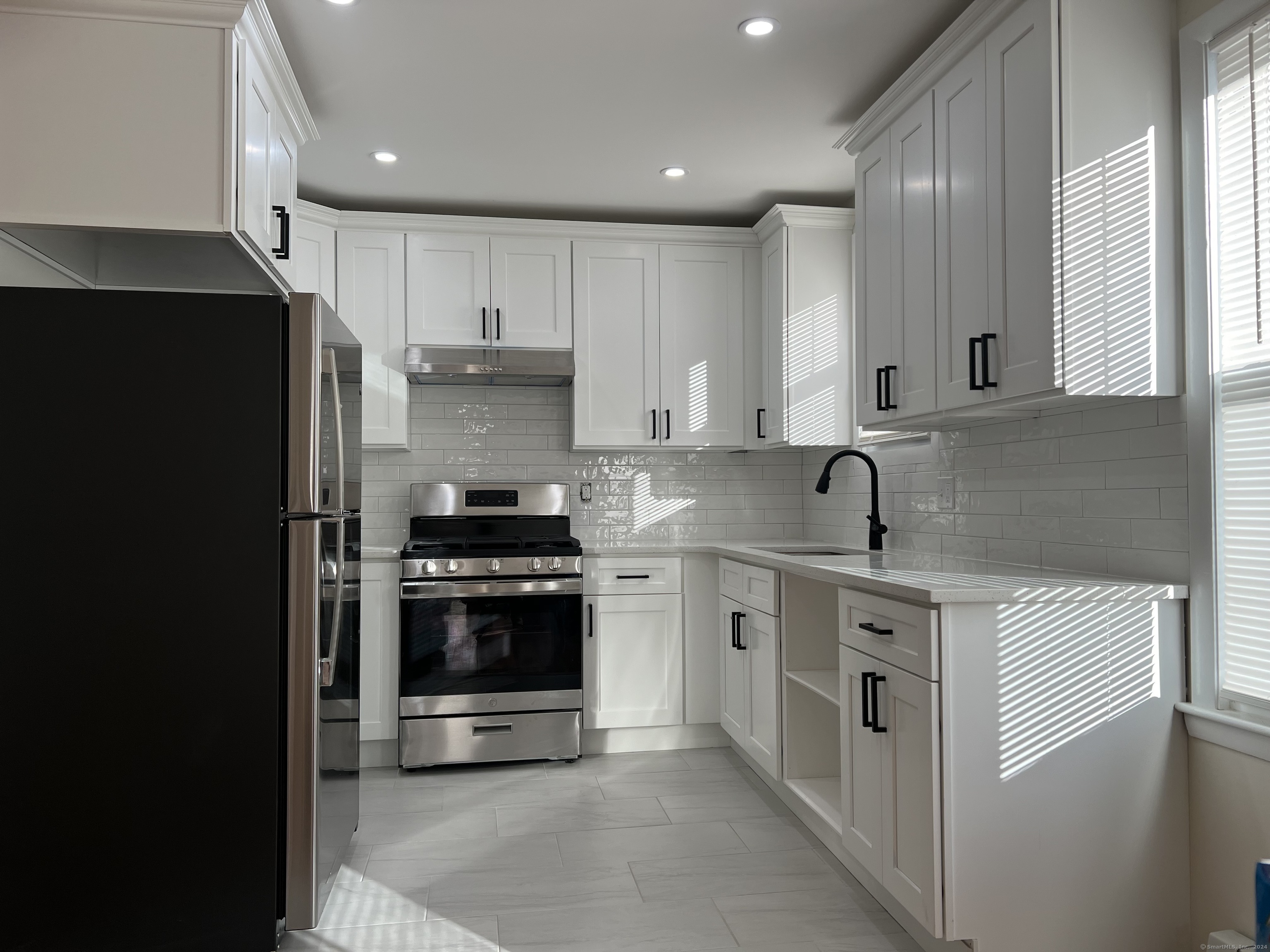 a kitchen with stainless steel appliances granite countertop a stove and a refrigerator