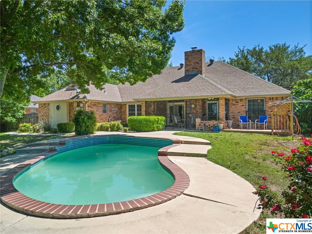 a view of a house with a swimming pool and garden