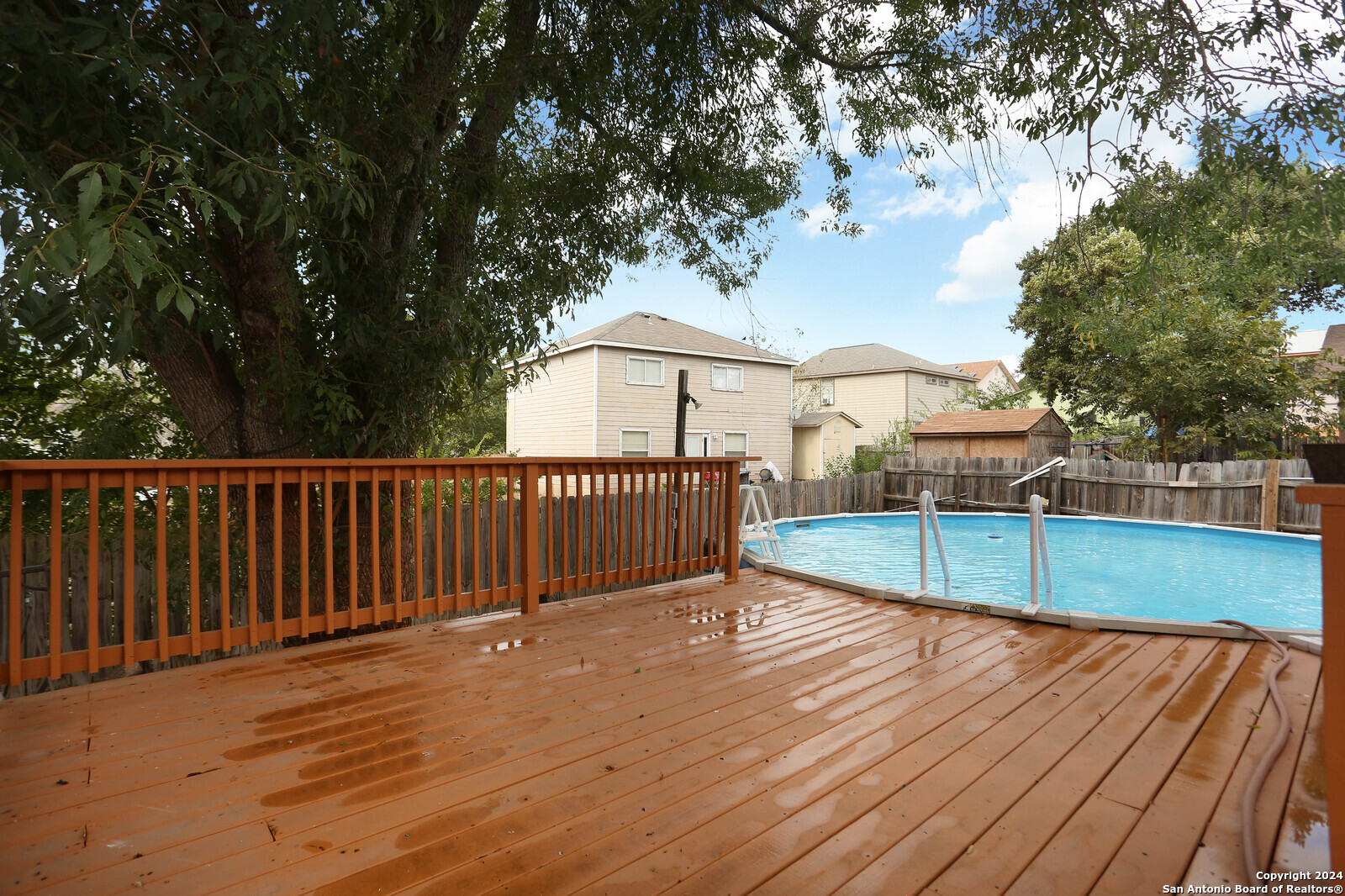 a view of a balcony with wooden floor and fence