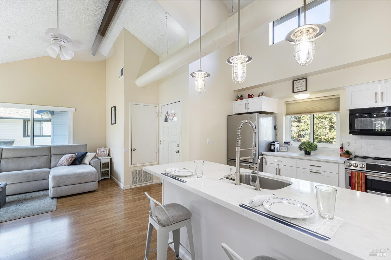 a kitchen with granite countertop a sink a counter top space appliances and cabinets