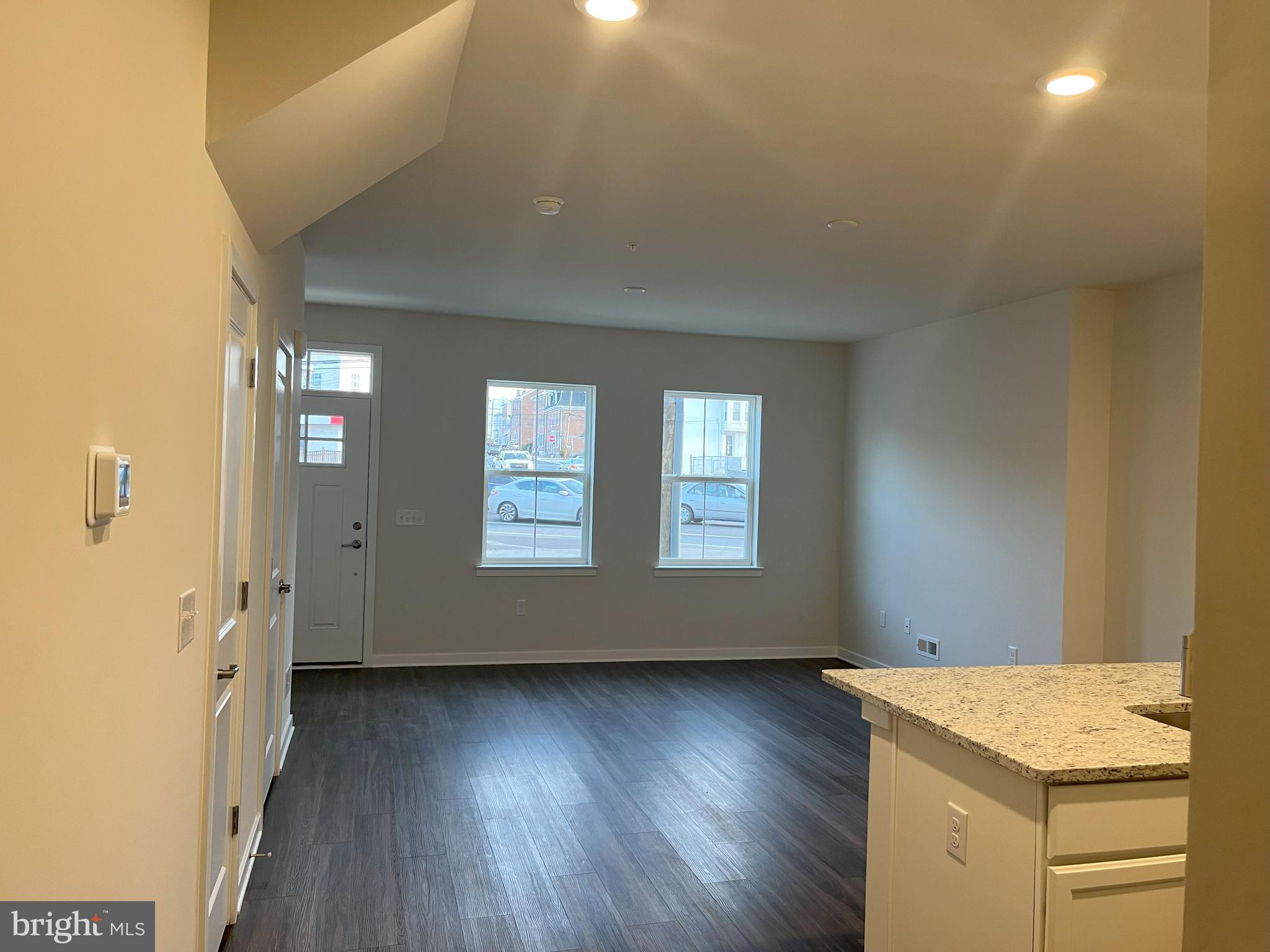 a view of a kitchen that shows a sink wooden floor and a window