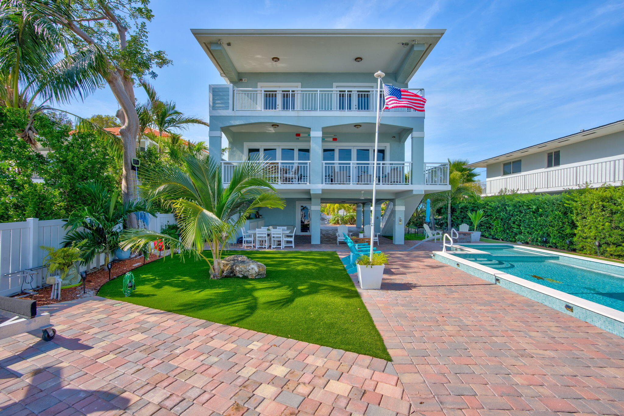 a front view of a house with a yard and potted plants