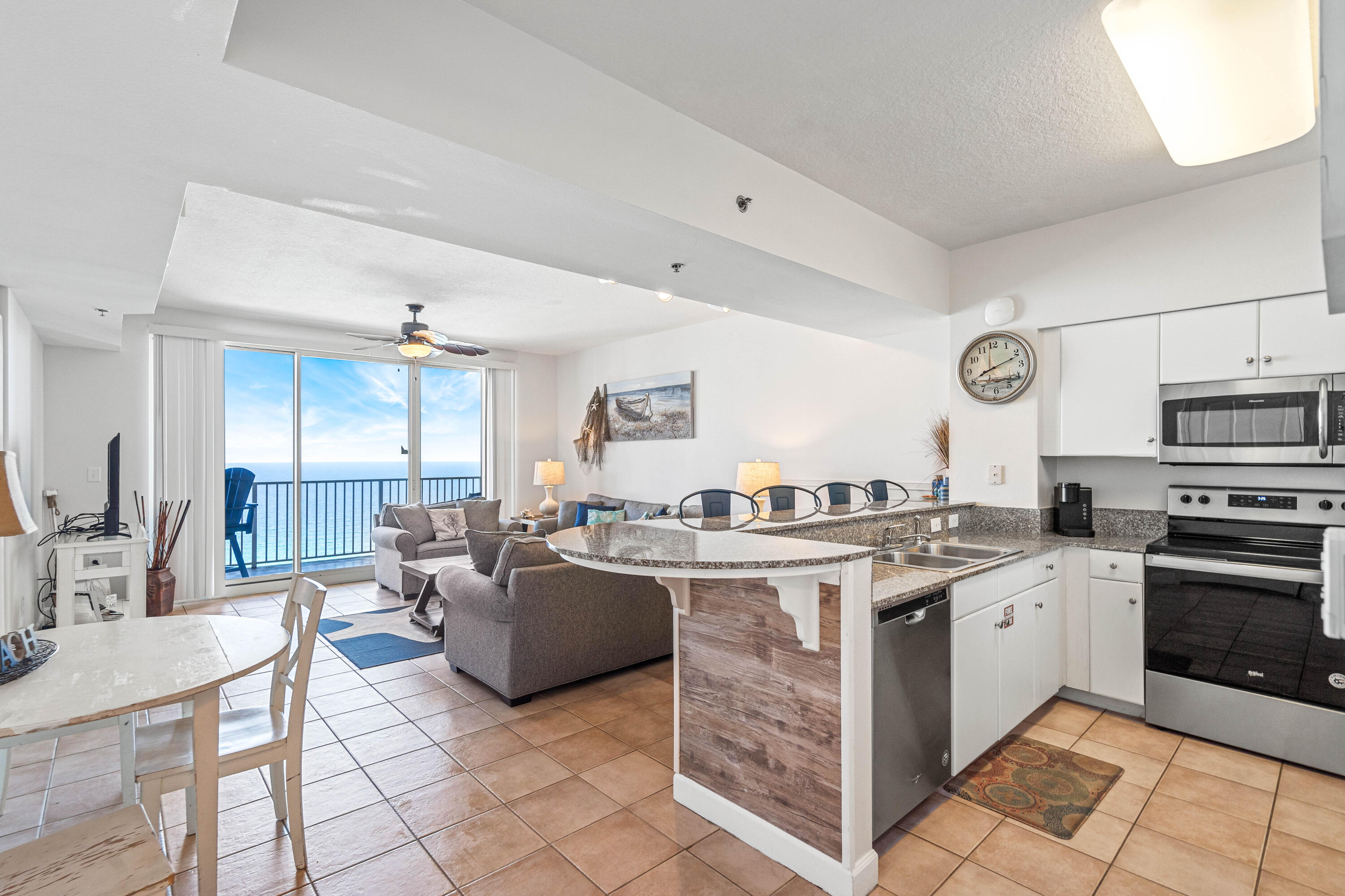 a kitchen with stainless steel appliances granite countertop a stove top oven a sink dishwasher and white cabinets next to a window