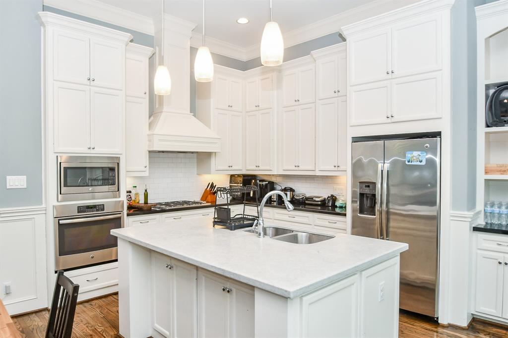 a kitchen with kitchen island a sink a stove and refrigerator