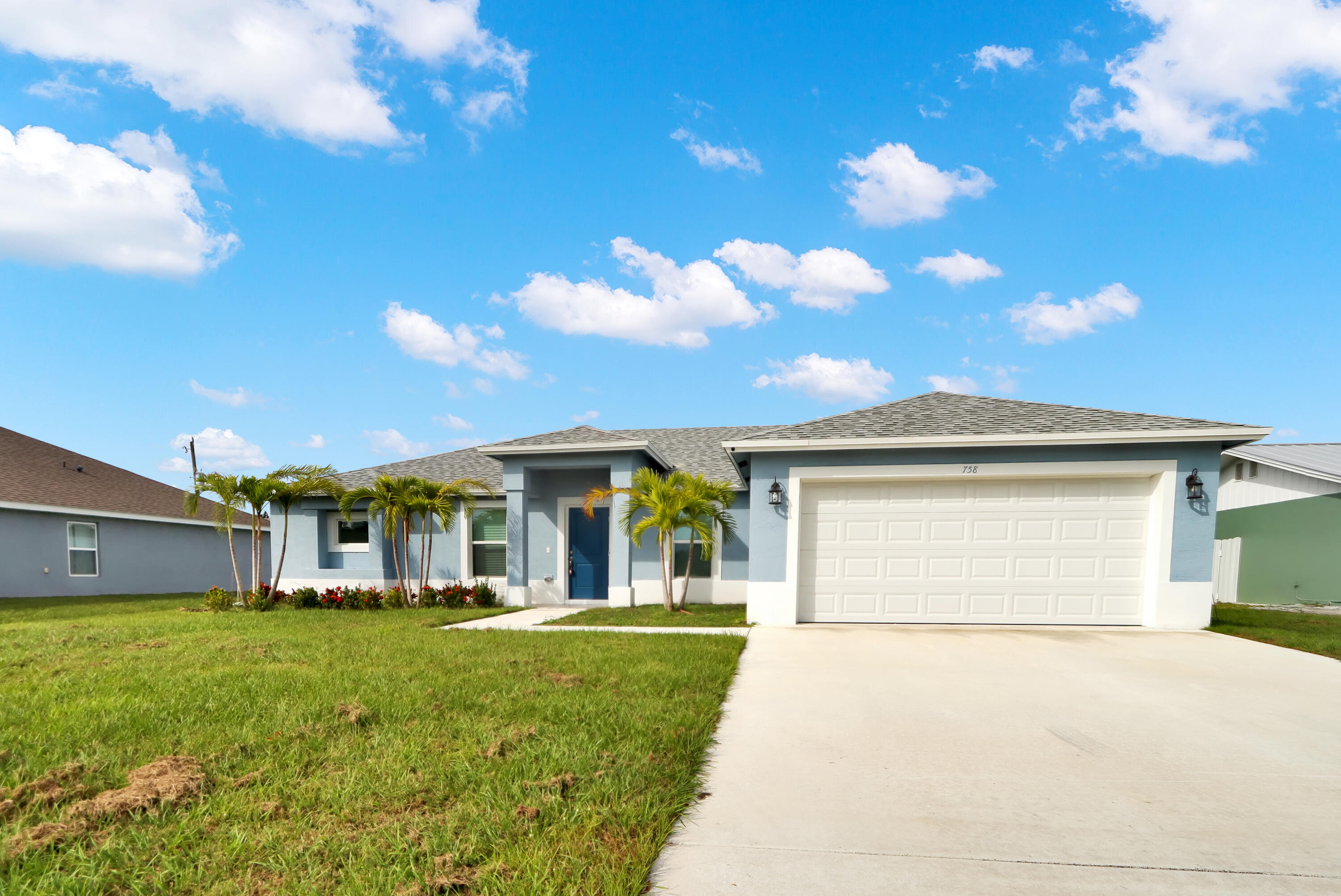 a front view of a house with a garden and yard