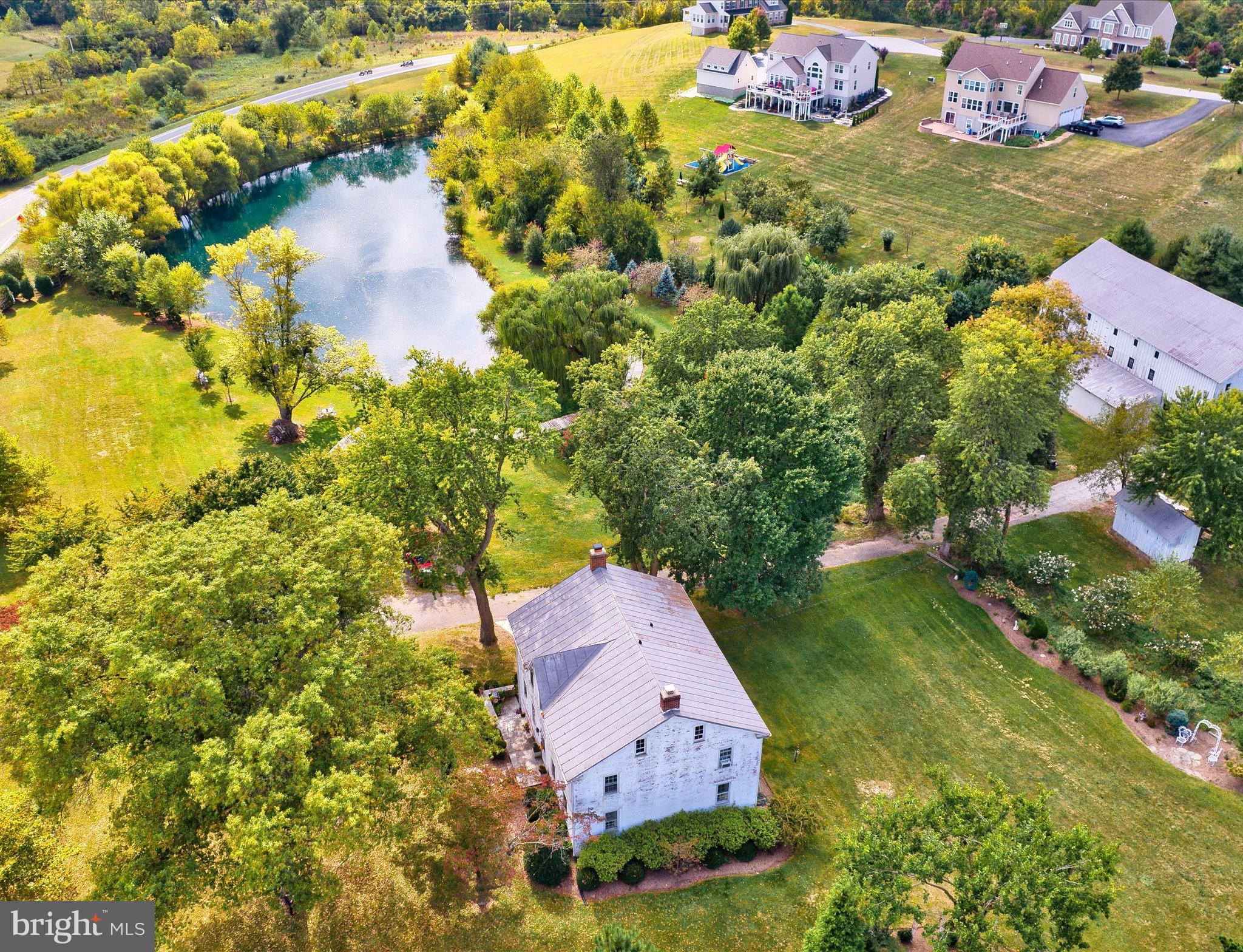 an aerial view of a house with a garden and lake view