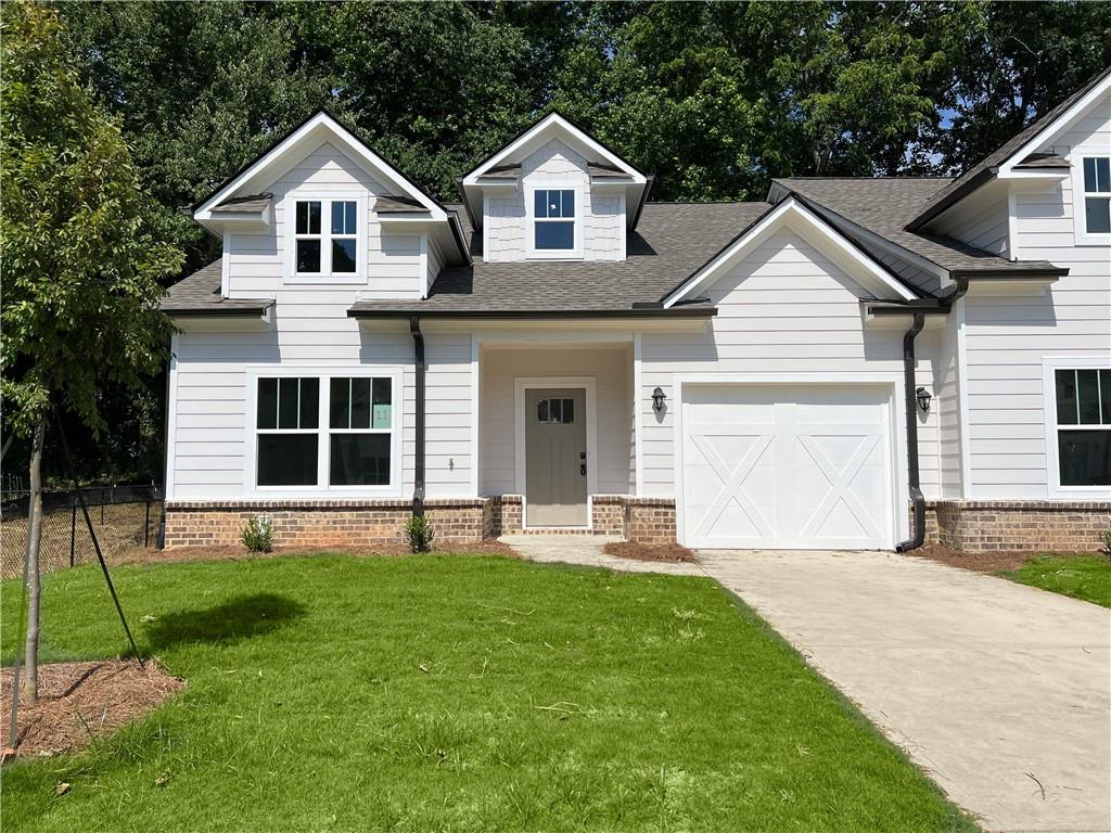 a front view of a house with a yard and trees