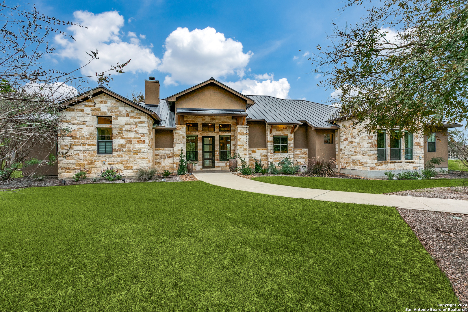 a front view of a house with a yard and trees