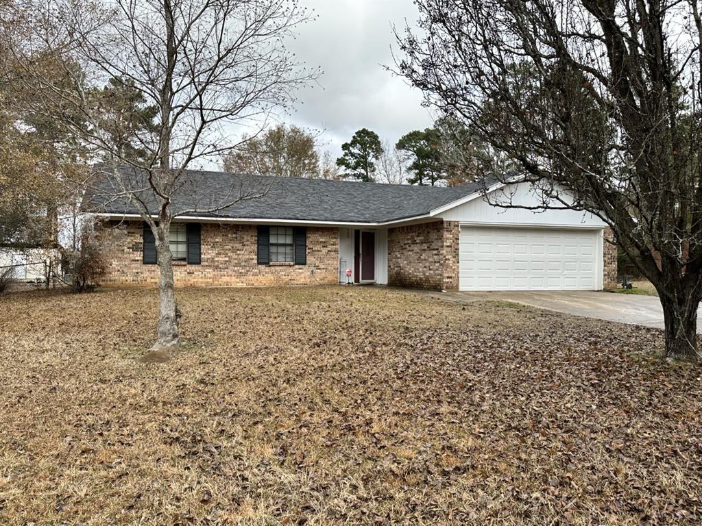 a front view of a house with a garden and trees