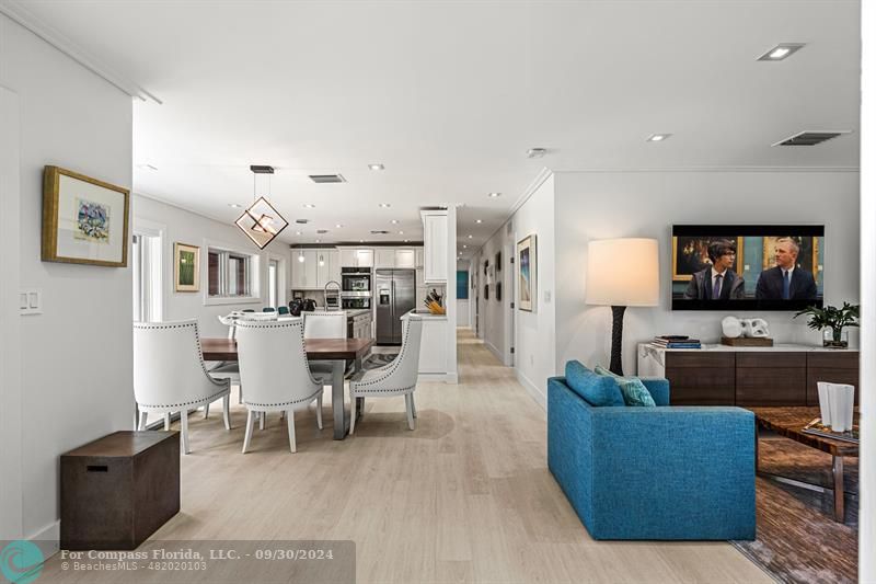 a living room with furniture kitchen view and a flat screen tv