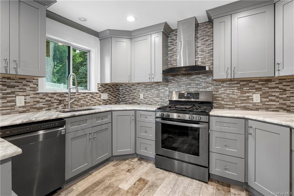 a kitchen with stainless steel appliances granite countertop a sink stove and cabinets