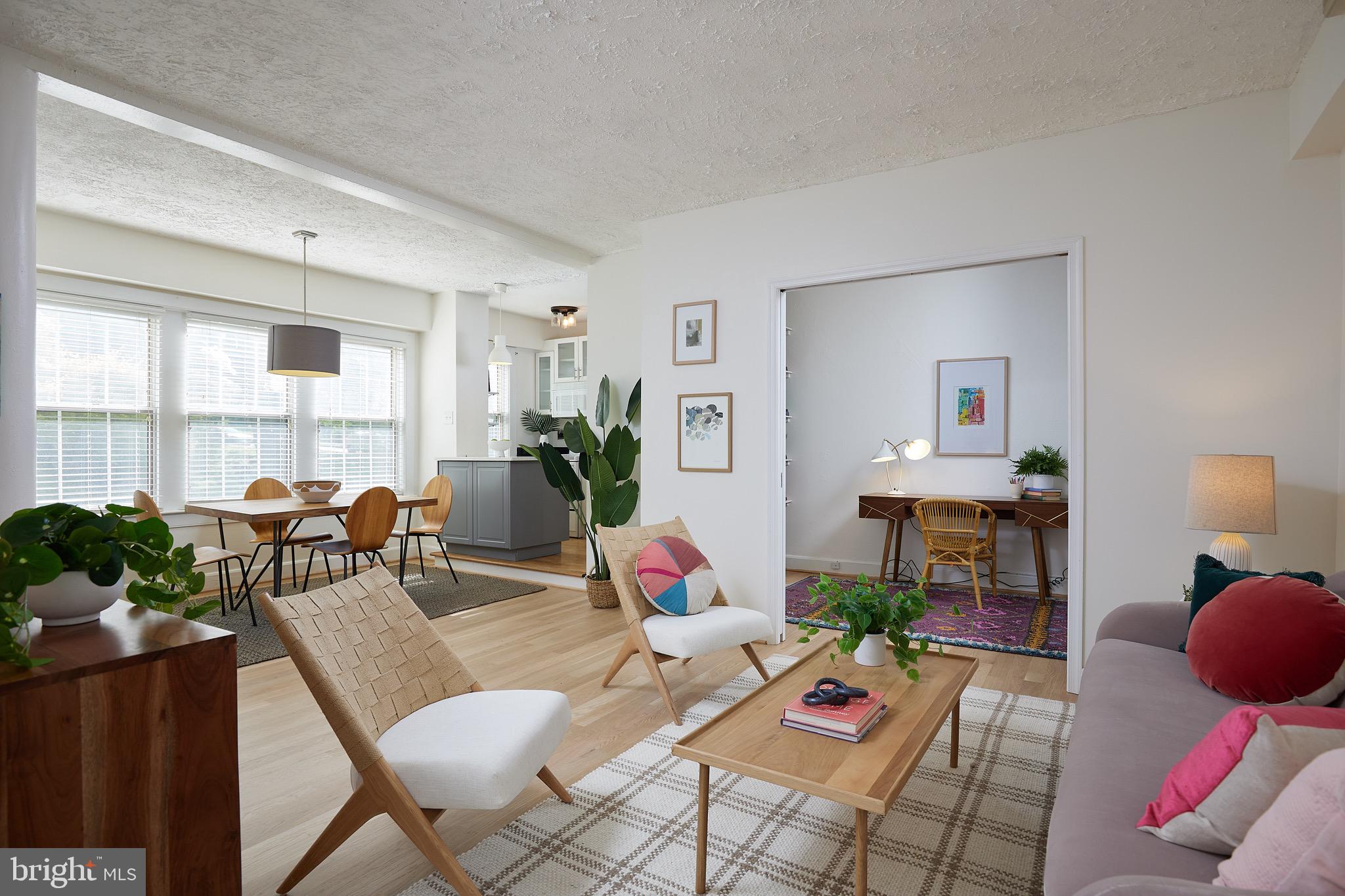 a living room that has couches and a dining table with garden view