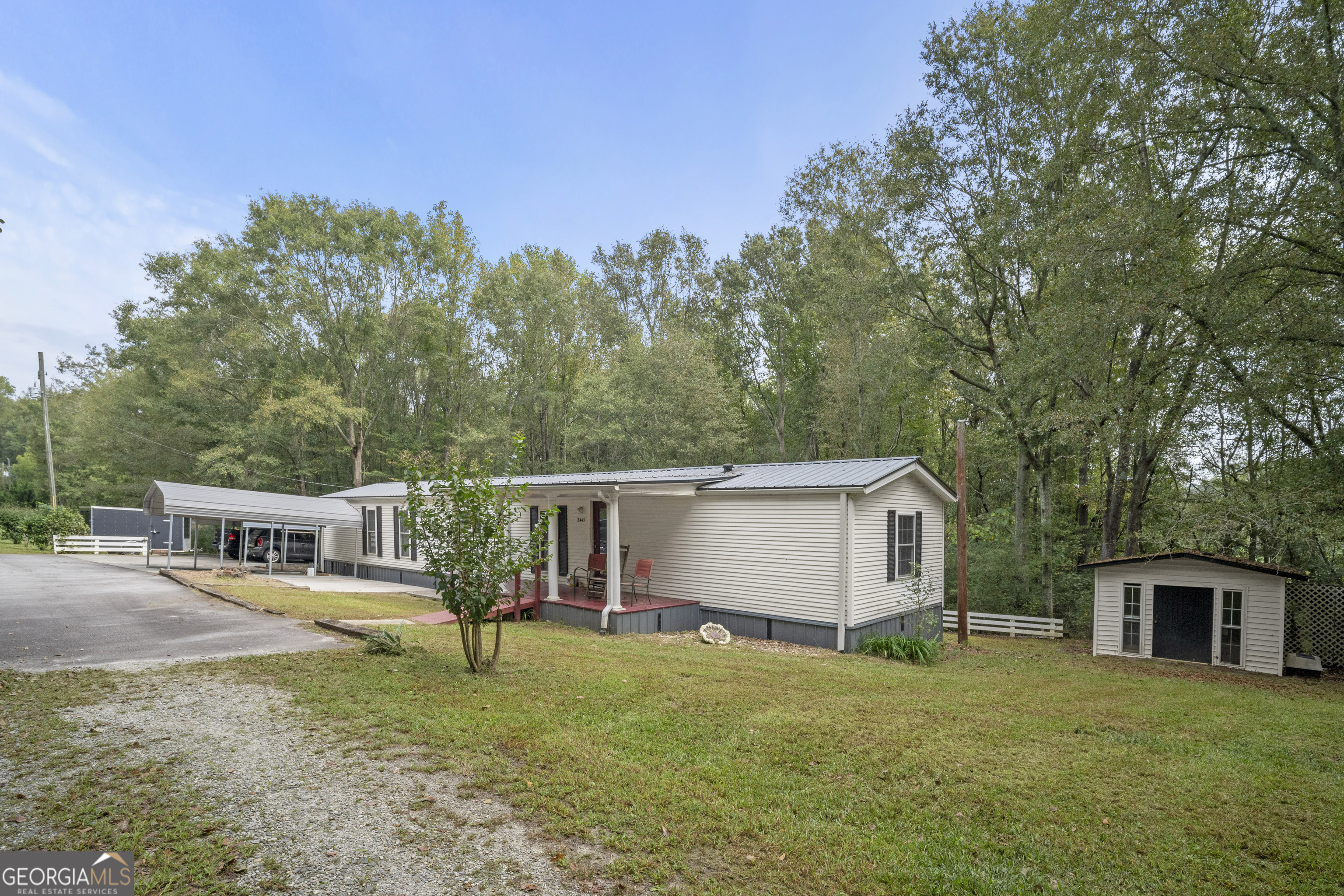 a view of a house with backyard and trees