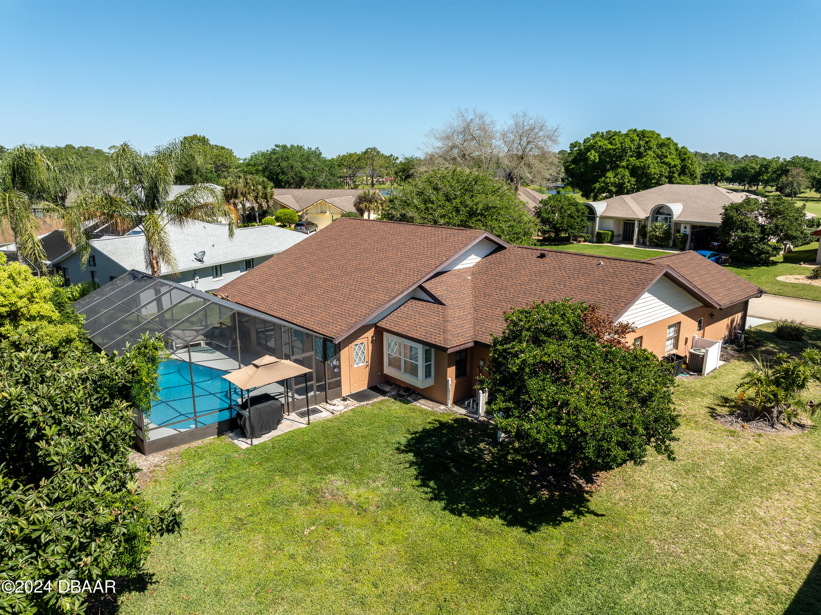 an aerial view of residential houses with outdoor space and trees