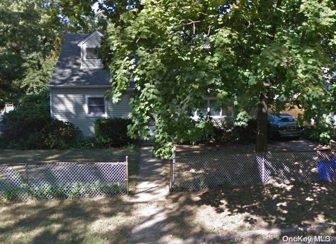 a view of a large yard with plants and large trees