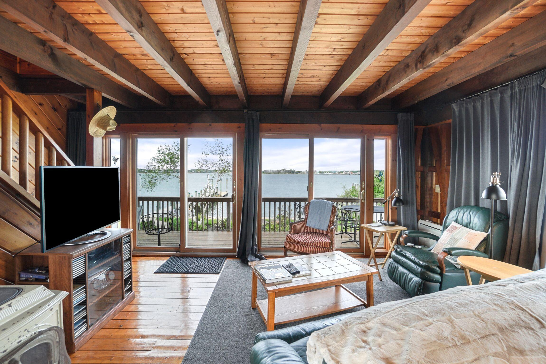 a living room with furniture a flat screen tv and a floor to ceiling window