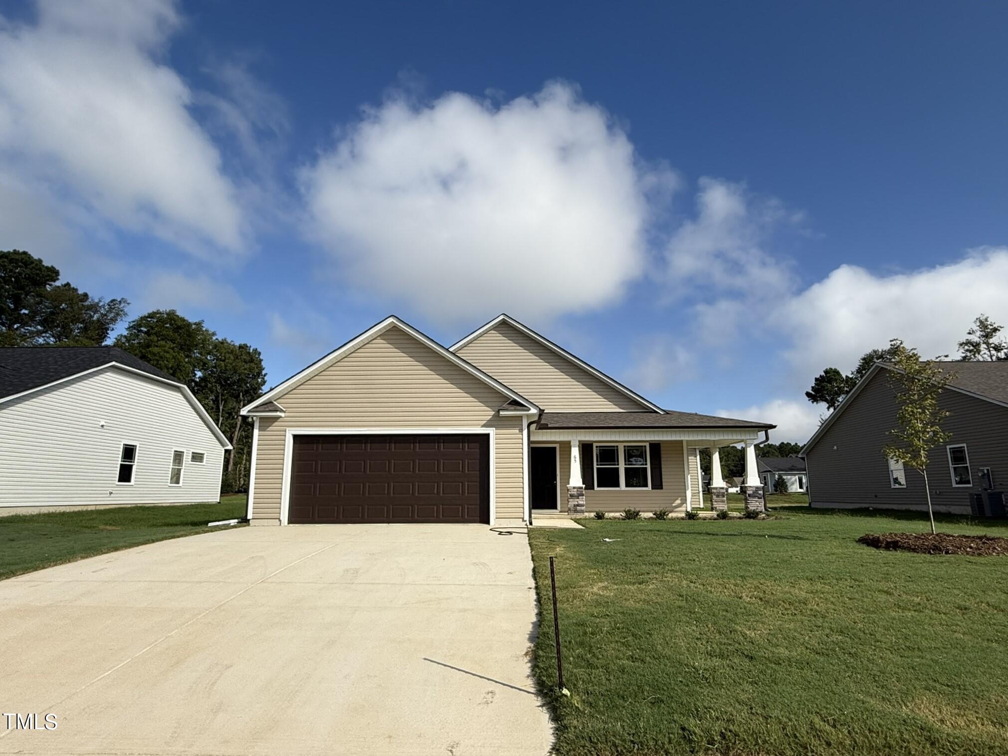 a front view of a house with a garden and yard