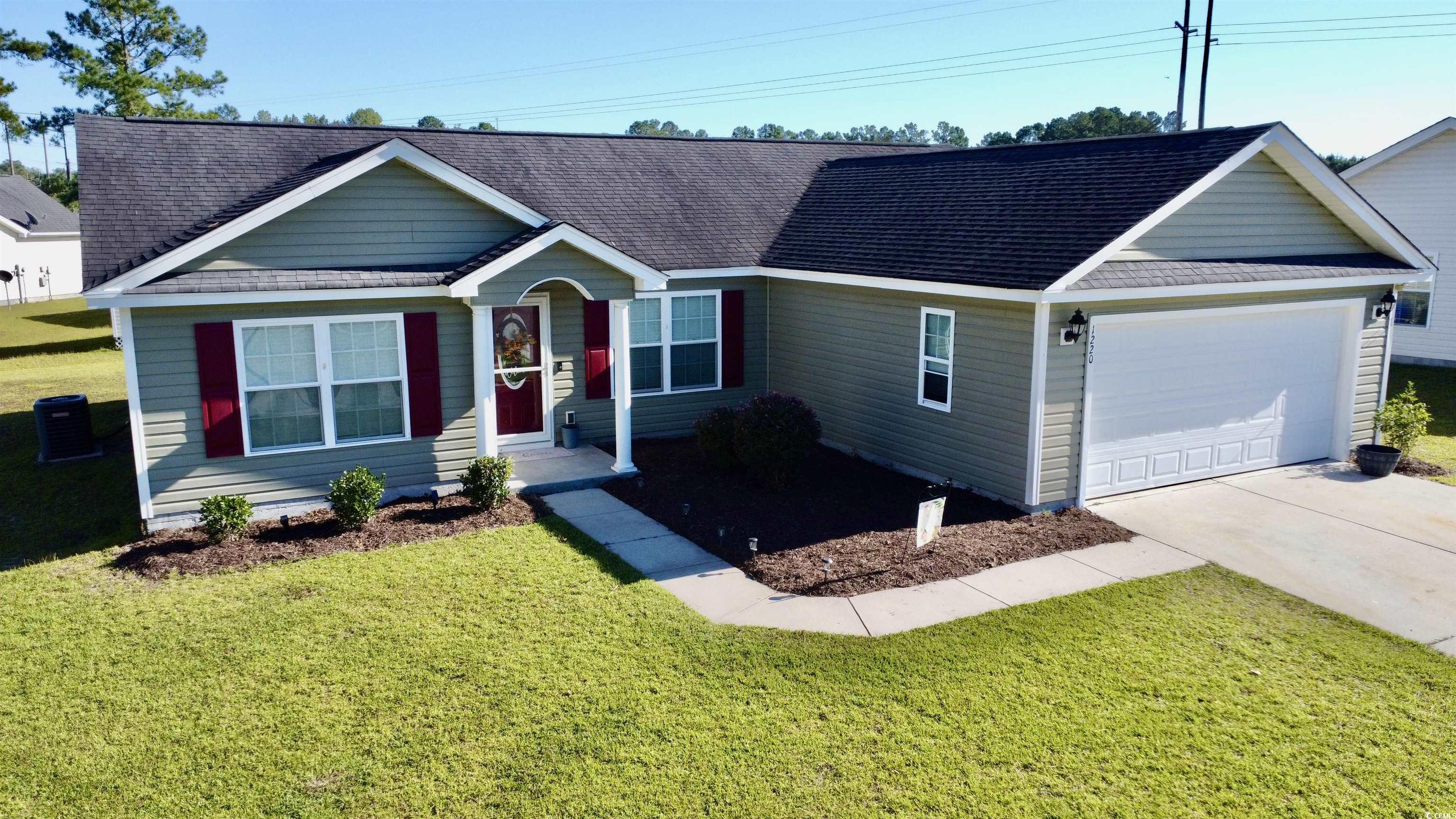 Ranch-style home featuring a front lawn and a gara