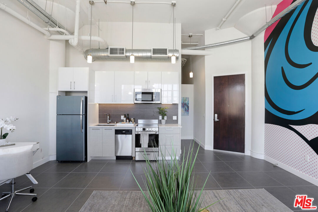 a kitchen with stainless steel appliances granite countertop a refrigerator and a sink